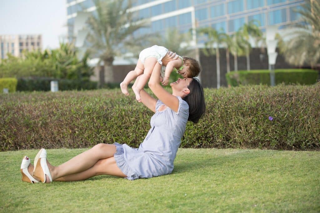 An australian mother plays with her child outside on the lawn